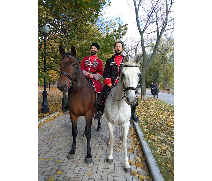 Два человека в национальных костюмах на лошадях