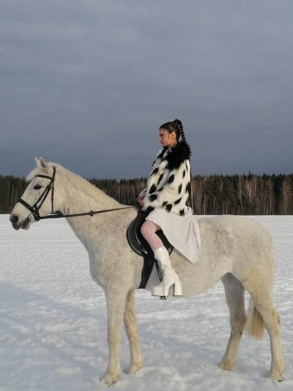 Фотография девушки верхом на белой лошади в поле