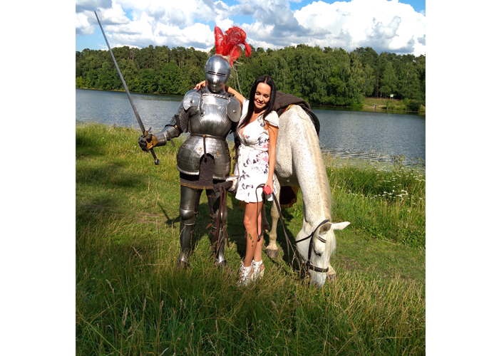 На фотографии мужчина в рыцарских доспехах, рядом девушка, которая уже стала невестой. Рядом с ними белая лошадь.