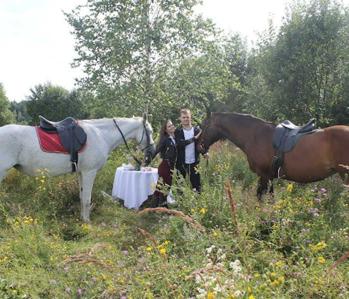 На фотографии фрагмент конной прогулки со столиком на конном маршруте